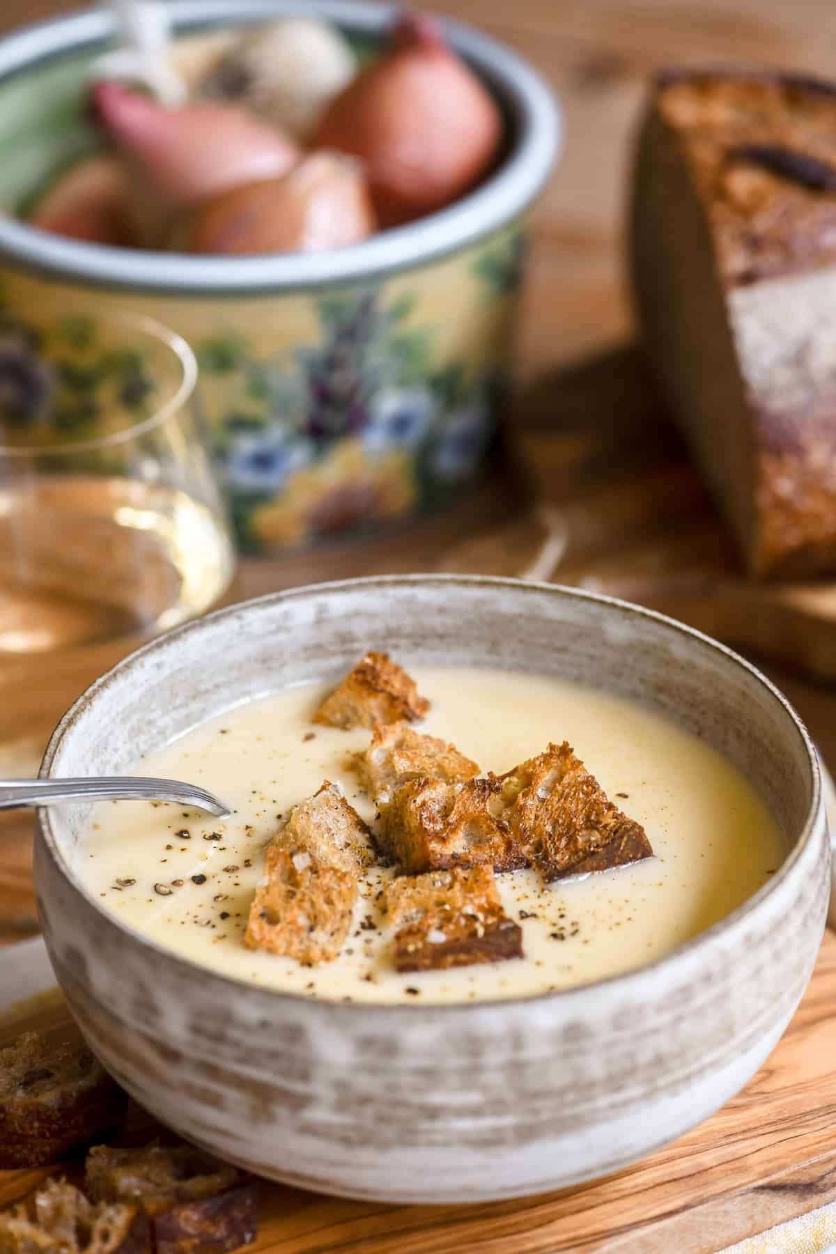 a bowl of cheesy fondue soup topped with rustic croutins.