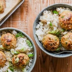 ginger scallion meatball bowls topped with sliced scallions and sesame seeds.