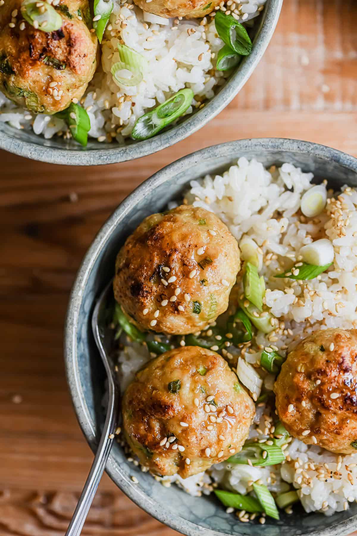 Ginger scallion chicken meatball bowls, garnished with sesame seeds.