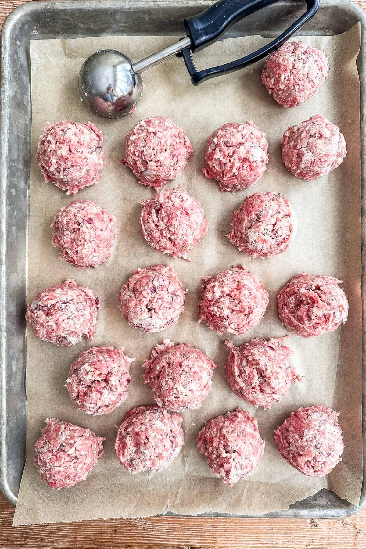 ricotta meatballs scooped out onto a parchment lined baking sheet.