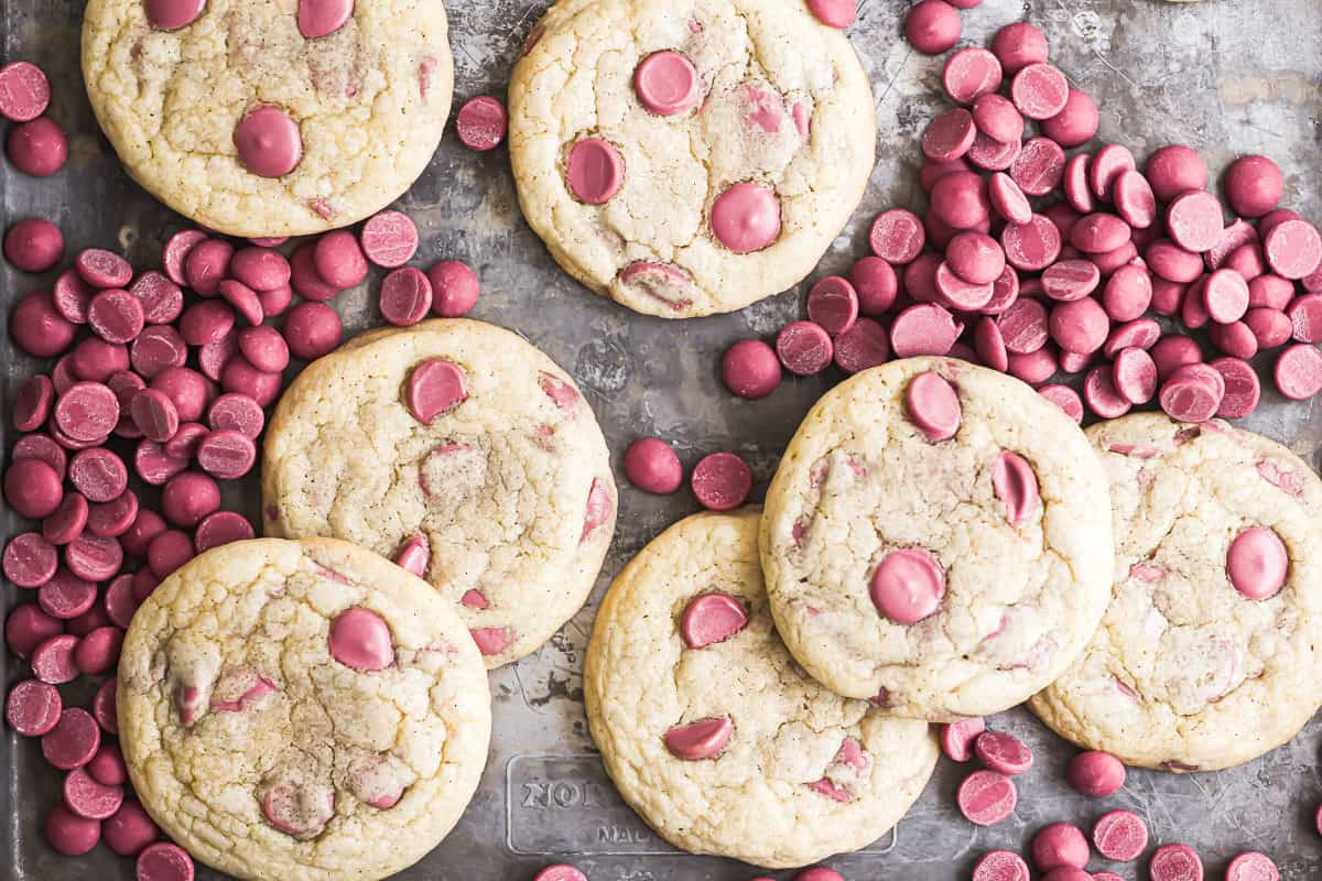 Ruby chocolate chip cookies on a sheet pan with ruby chocolate chips