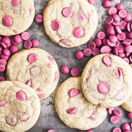 Ruby chocolate chip cookies on a sheet pan with ruby chocolate chips