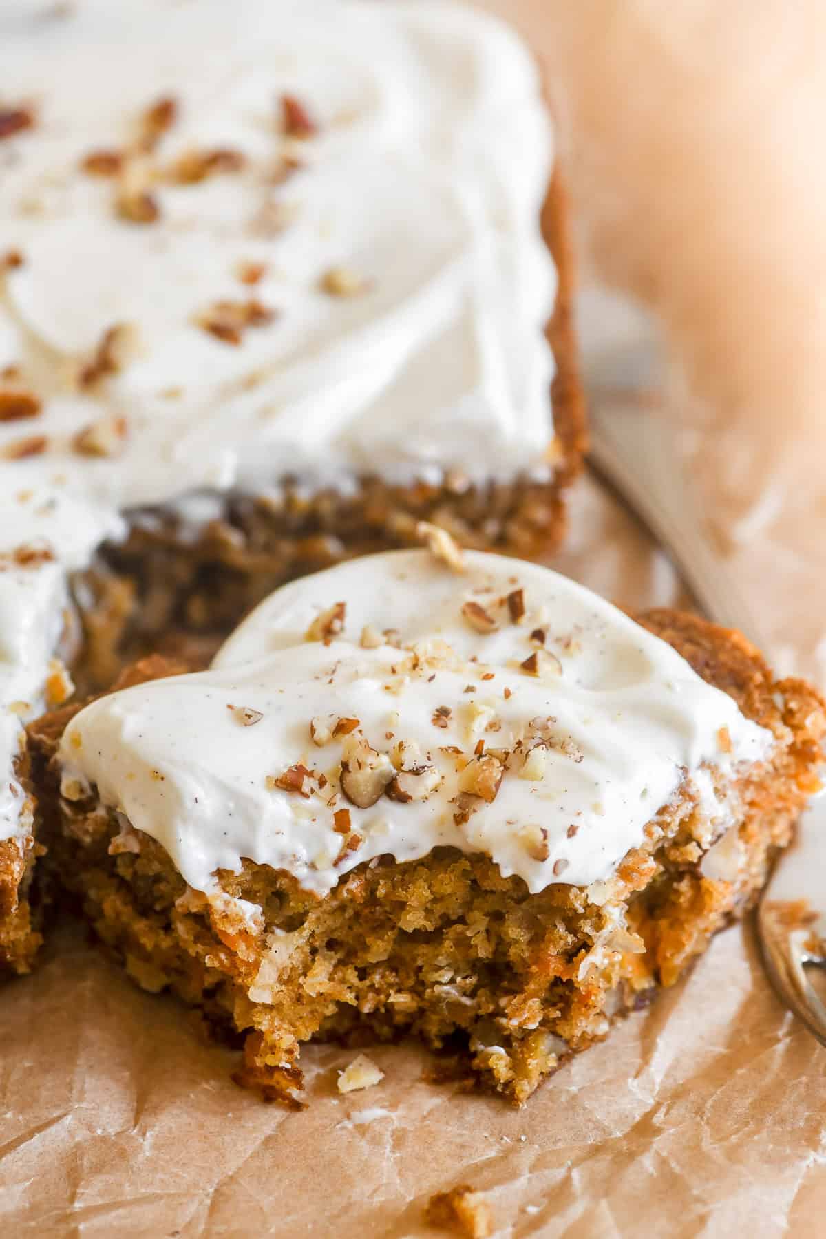 Carrot Cake bars, sliced and topped with cream cheese frosting and toasted pecans.
