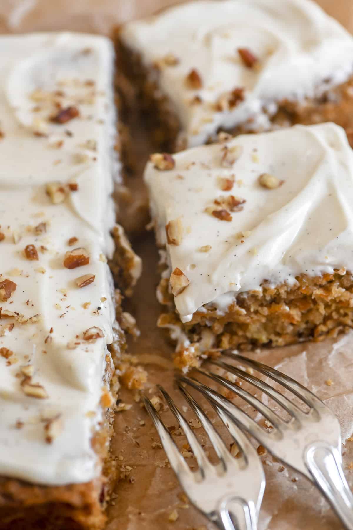 Sliced carrot cake bars with forks,.