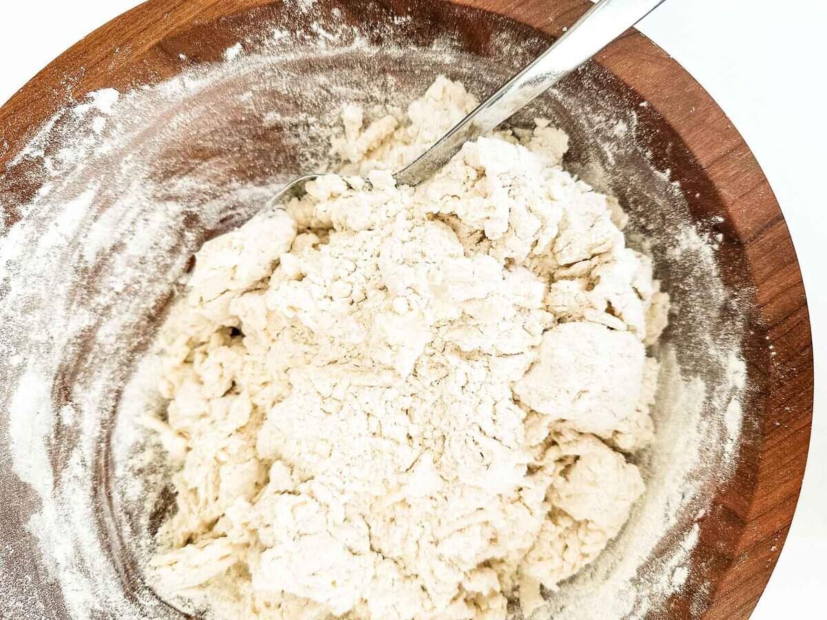 Making irish Soda Bread in a wooden bowl with a spoon.
