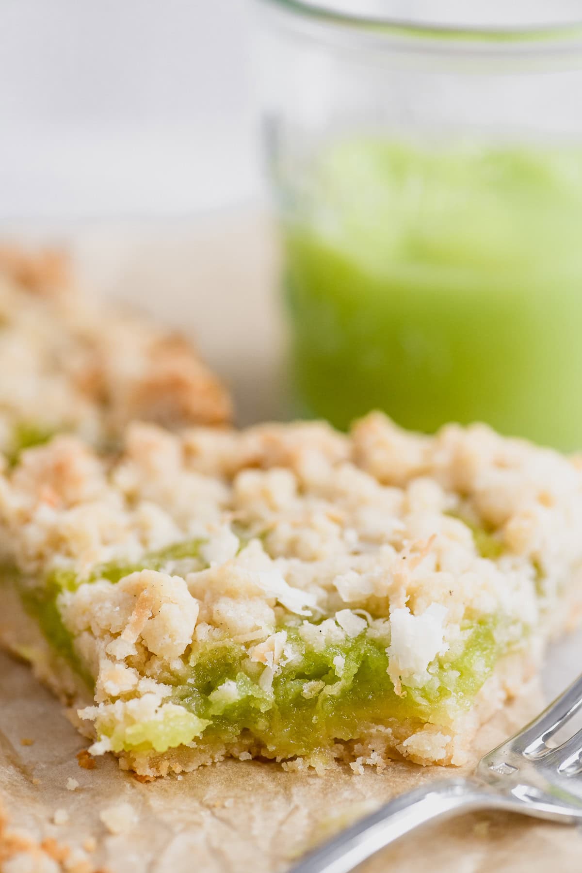 A slice of coconut lime shortbread tart with bite taken. 