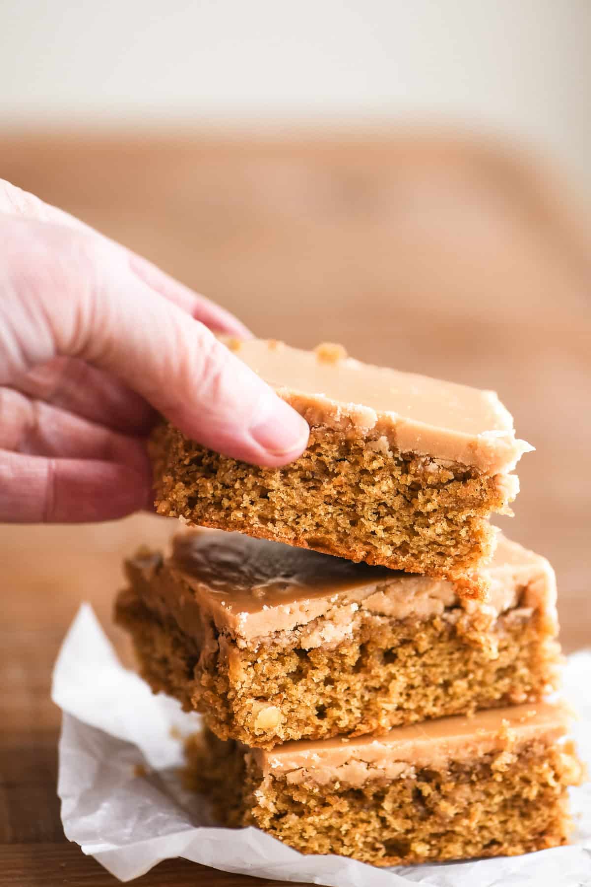 Taking a piece of coffee fudge cake from a stack.