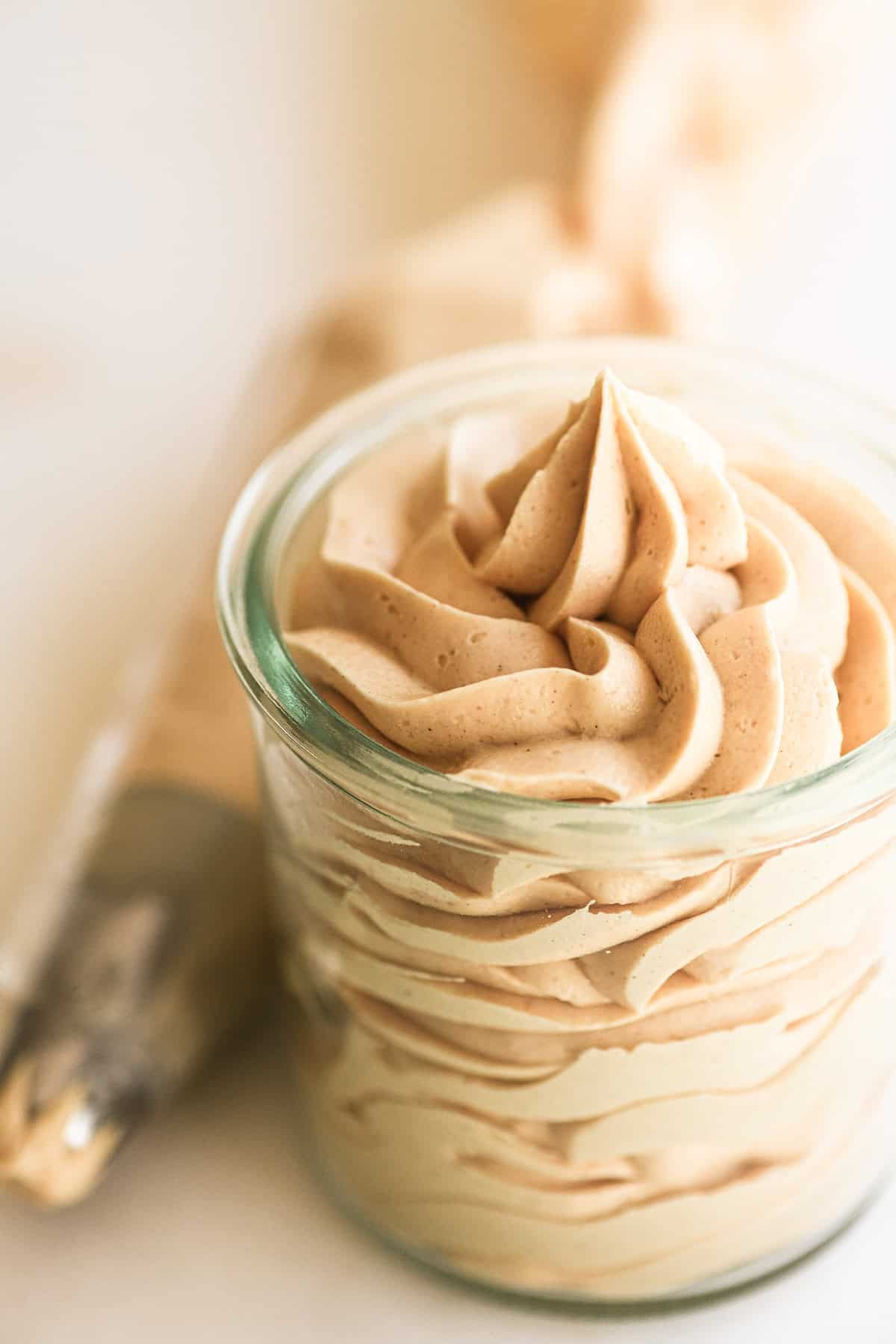 Peanut butter frosting piped into a jar.