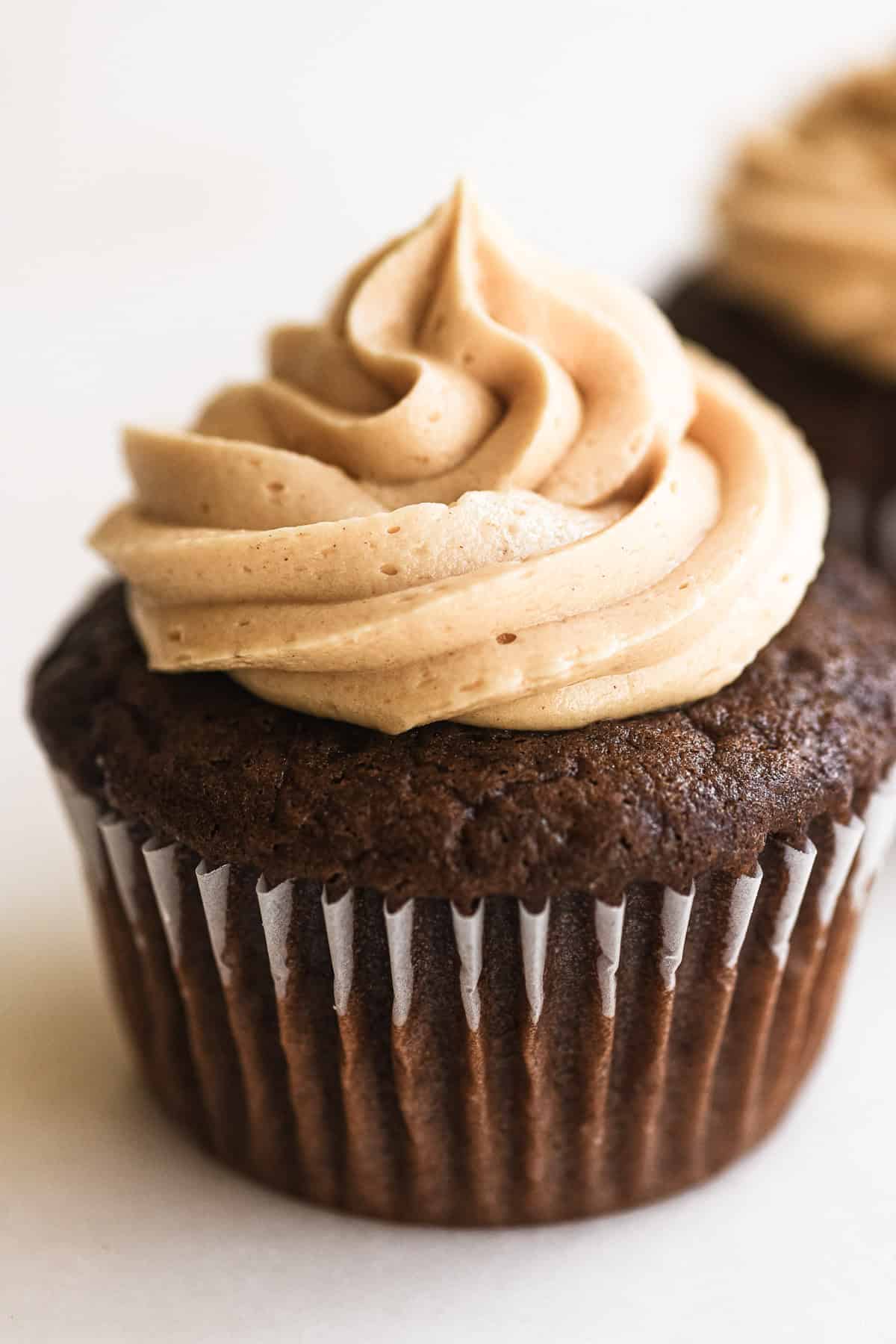 a milk chocolate cupcake with piped peanut buttercream frosting.