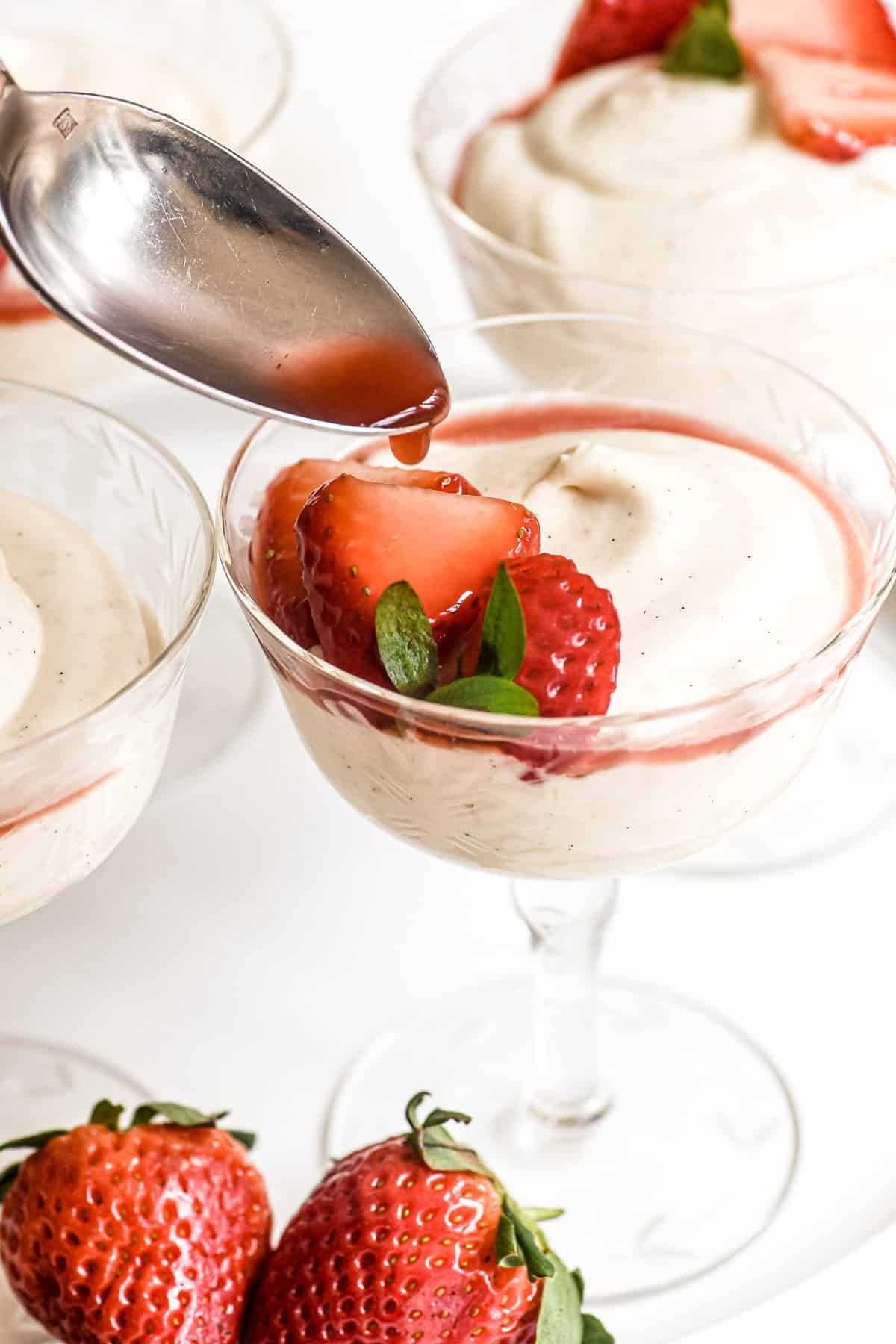 spooning strawberry juice on white chocolate mousse.