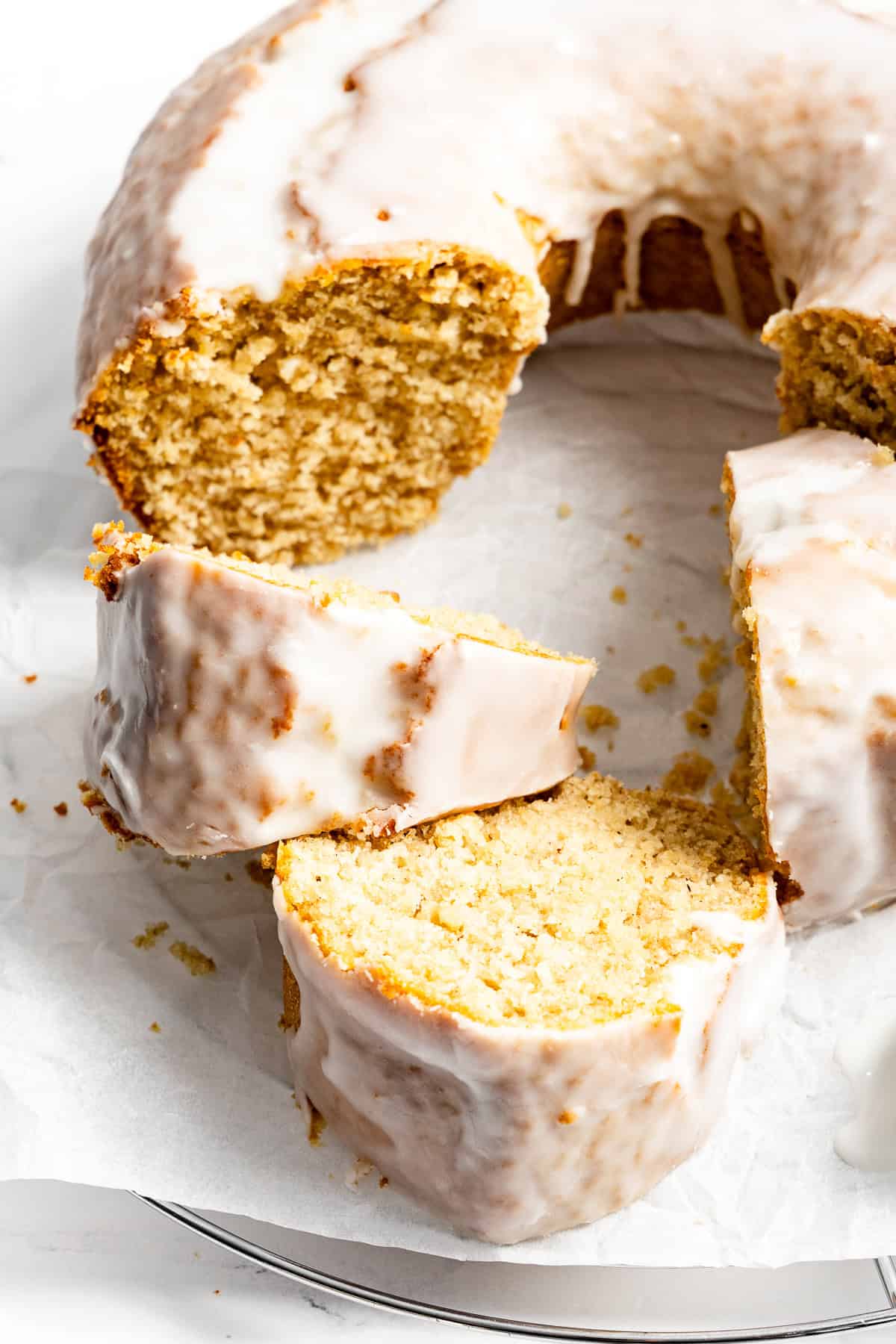 A glazed old fashioned doughnut cake, sliced on a plate.