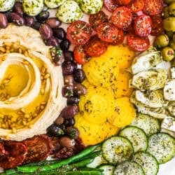 hummus mezze platter with colorful marinated veggies and cheese.