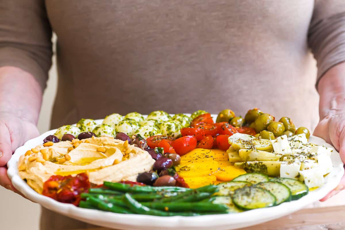 Holding a hummus mezze platter.