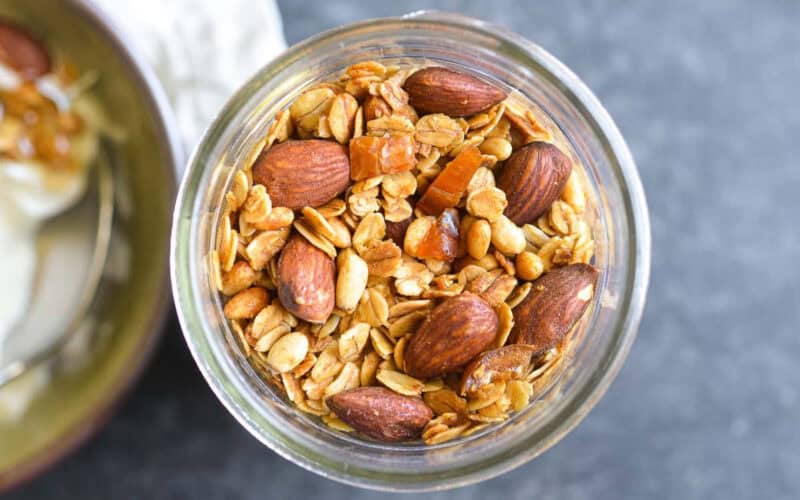 a jar of olive oil granola with almonds.