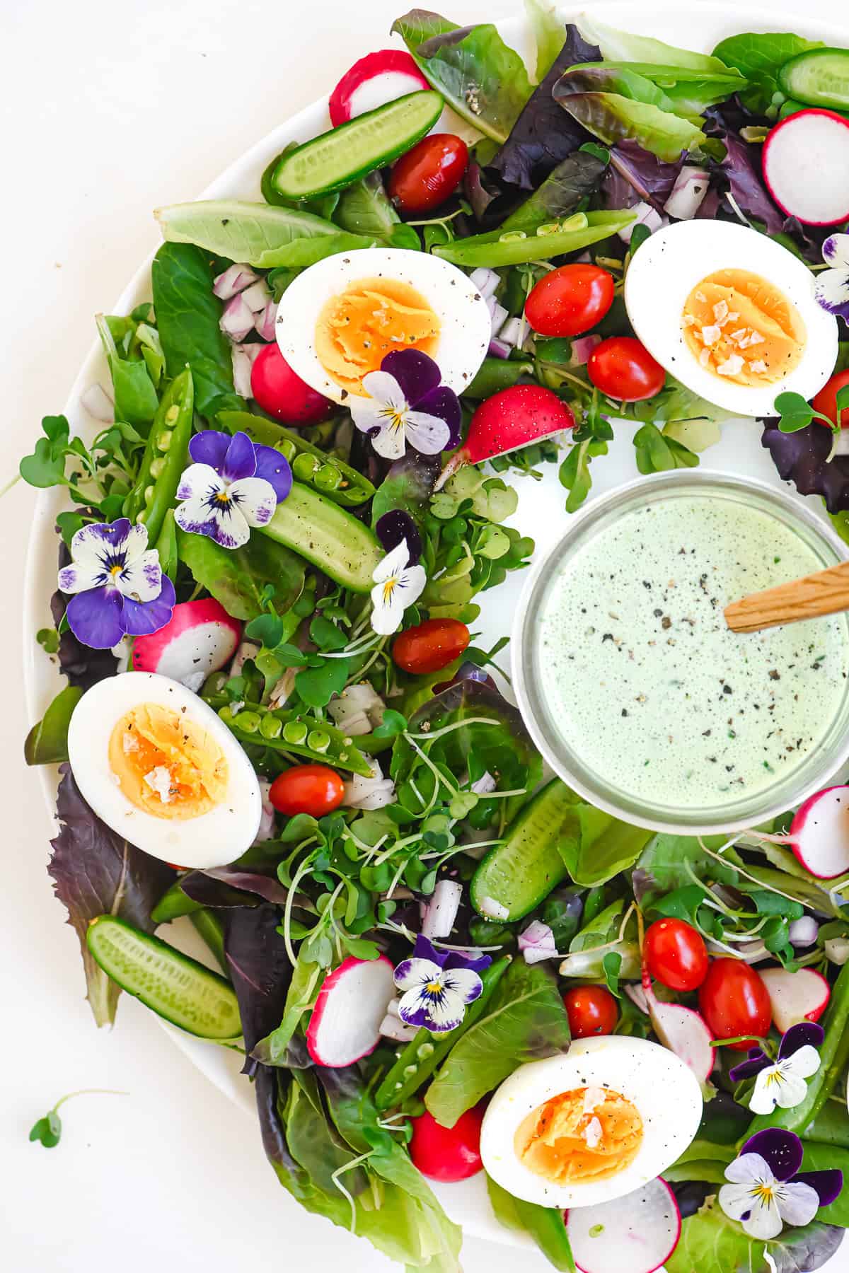 spring wreath salad with little jar of basil buttermilk dressing in center.