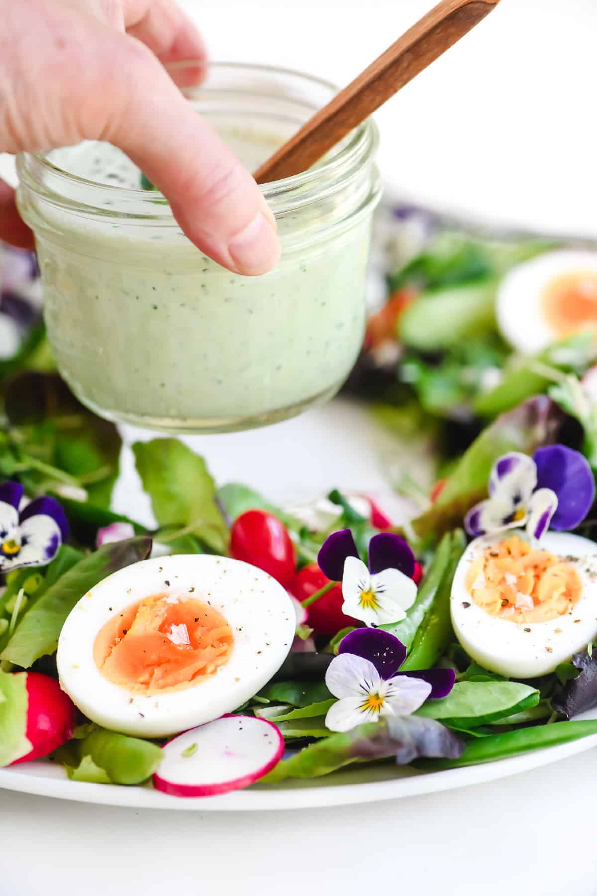 Placing a small jar of basil buttermilk dressing in the center of a spring salad wreath platter.