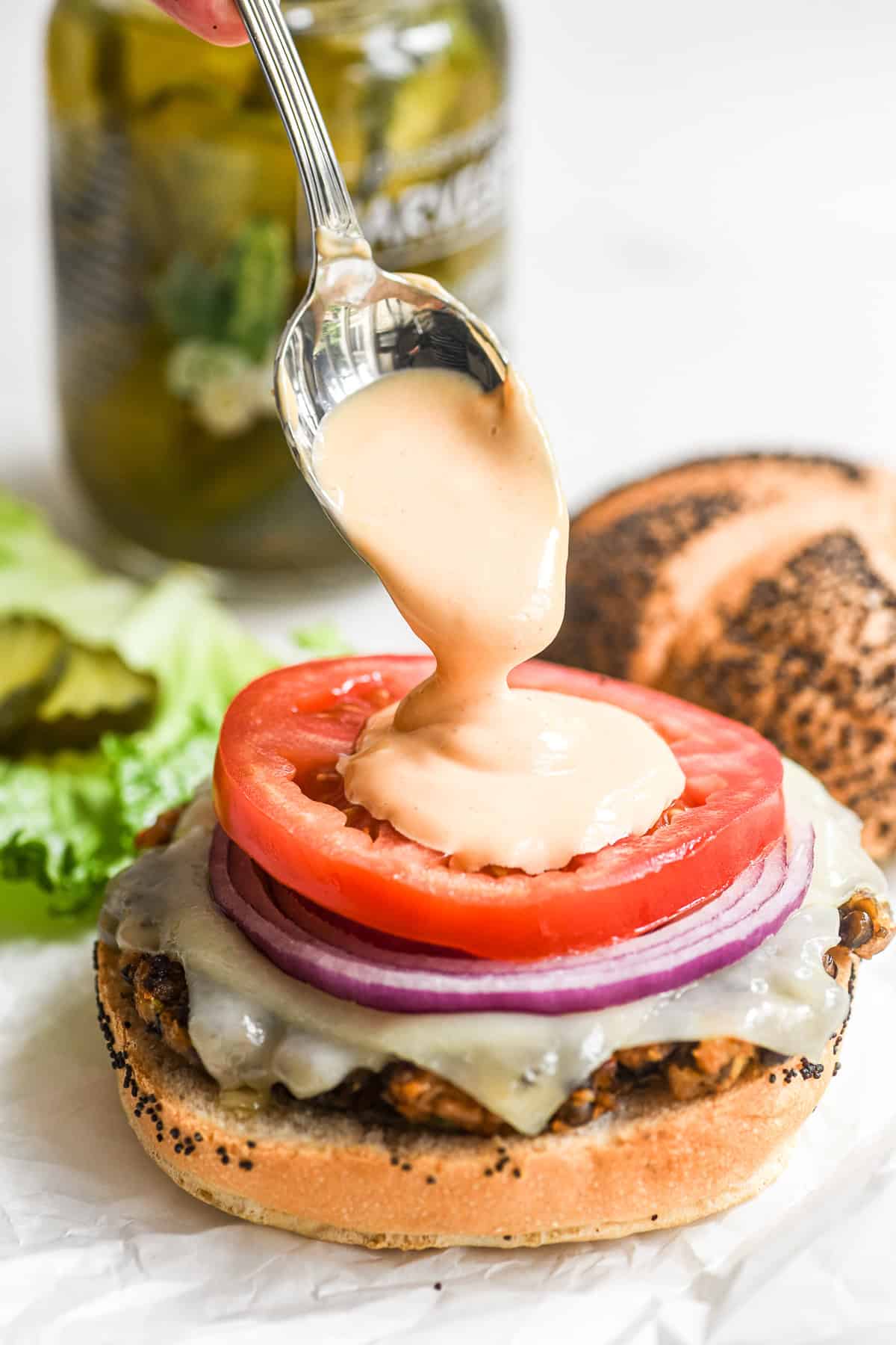 adding special sauce to a veggie smashburger