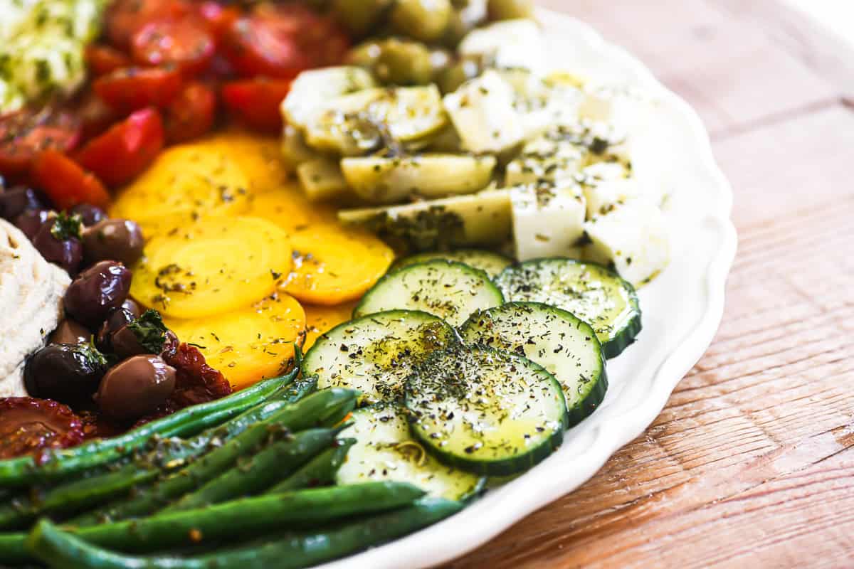 an appetizer platter of marinated veggies and hummus.