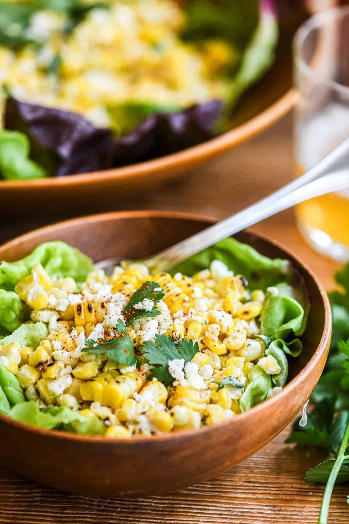 Mexican Street Corn Salad (Esquites) being served in a small wooden bowl.