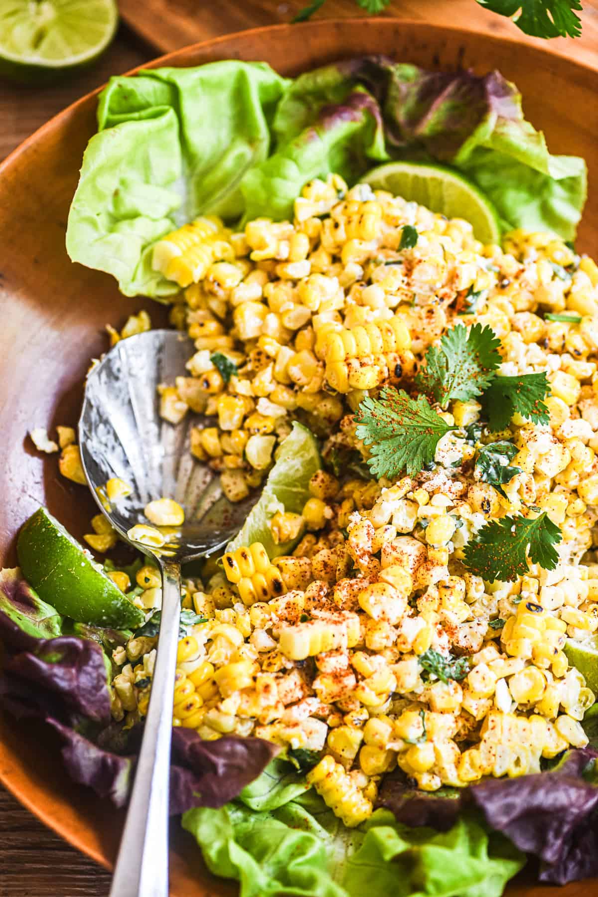 Mexican street corn salad with a serving spoon.