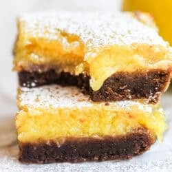 Black bottom lemon bars, stacked, with bite taken.