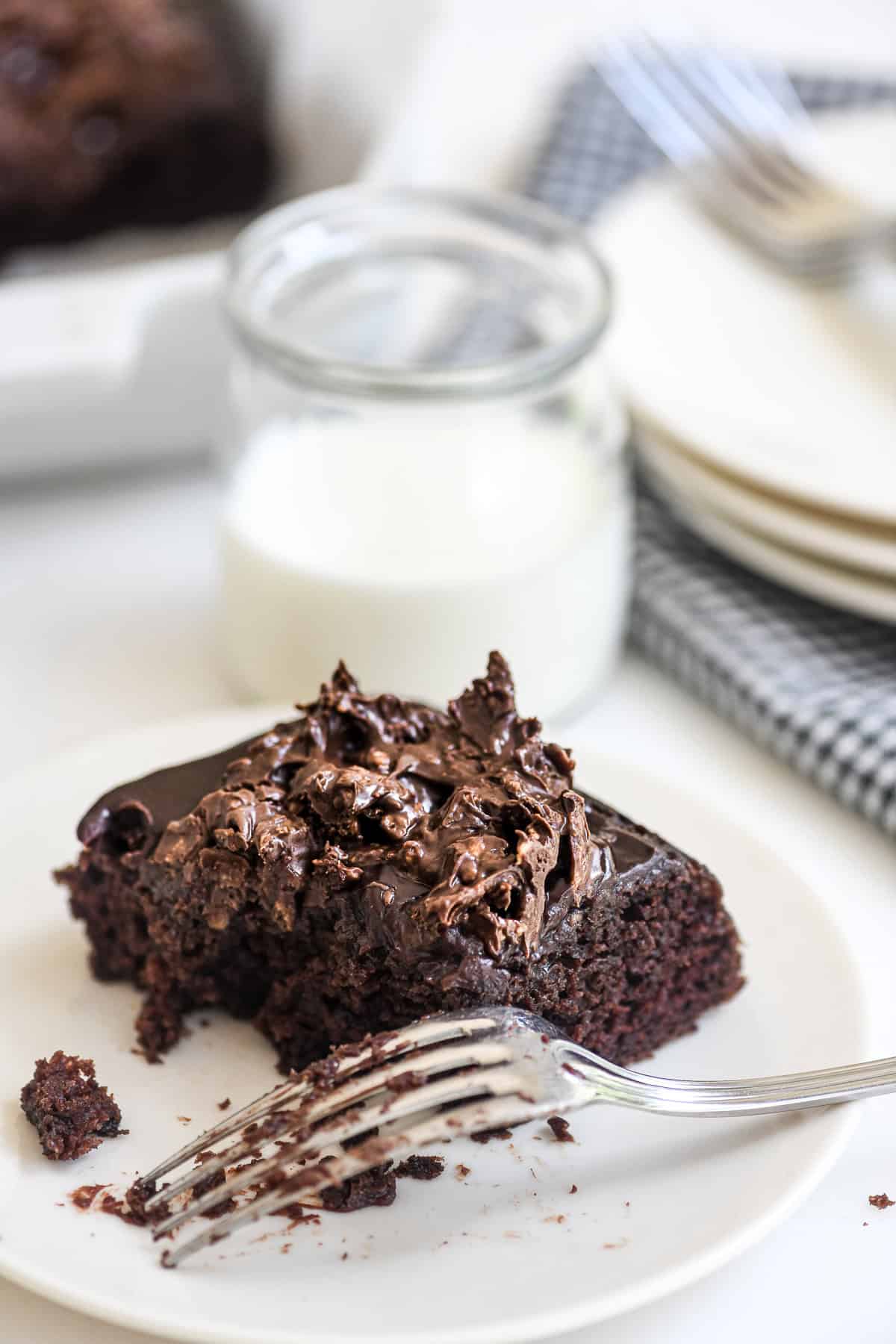Taking a bite of a small piece of chocolate crunch cake with a fork.
