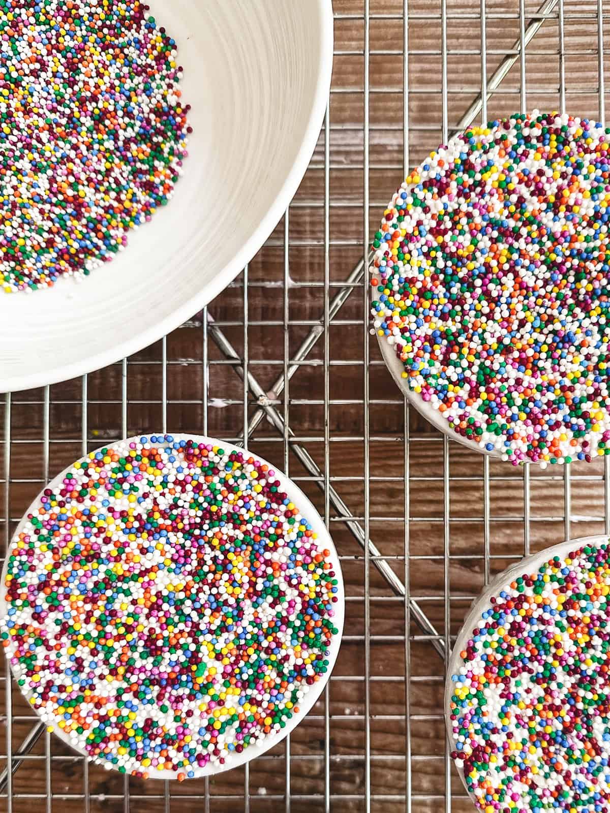 Dot cakes on a rack, with sprinkles.