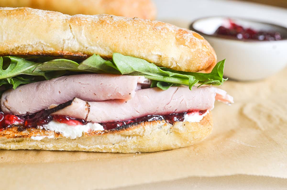 ham and jam sandwich on a roll, with arugula.