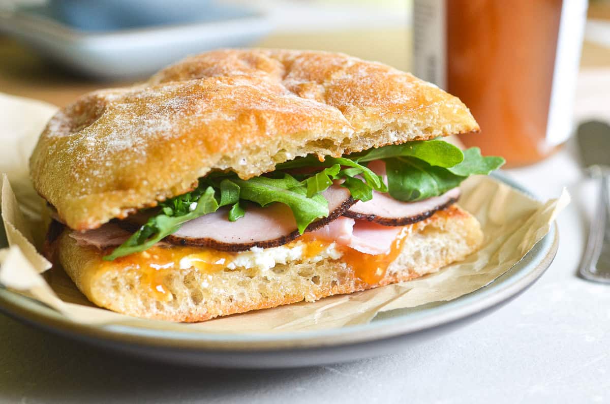 Ham and jam sandwich on a plate with jam dripping down.