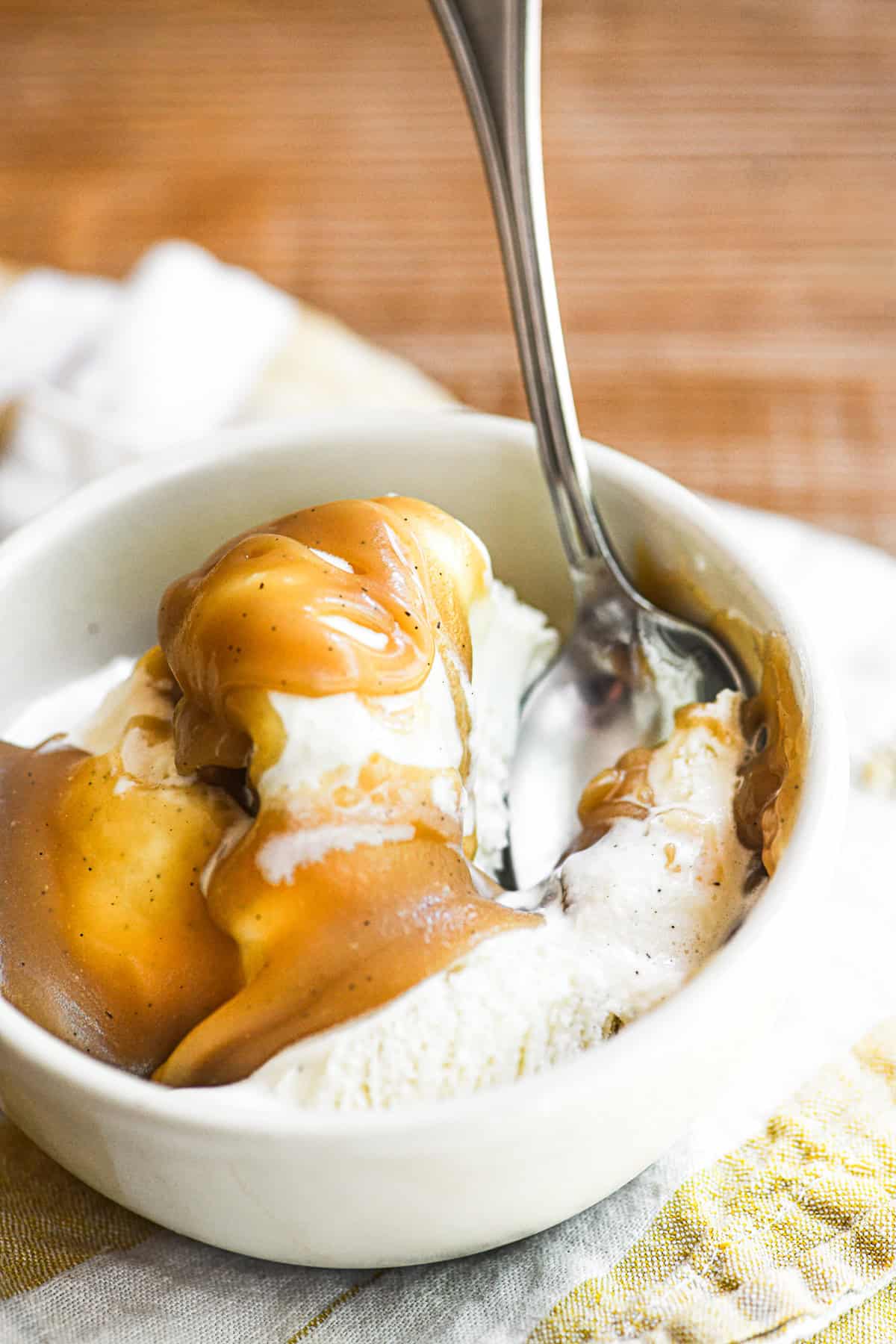homemade butterscotch sauce on a bowl of vanilla bean ice cream.