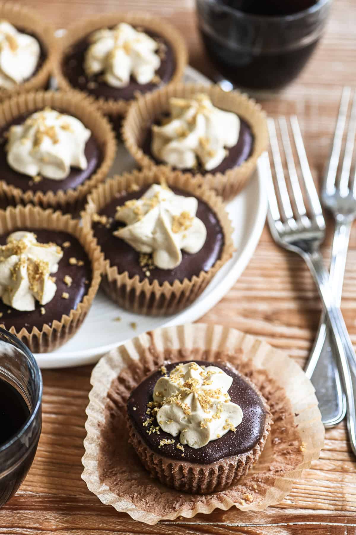 Mini mocha cheesecakes on a platter with small cups of espresso.