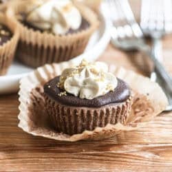 mini mocha cheesecake topped with coffee whipped cream, with paper liner peeled away.