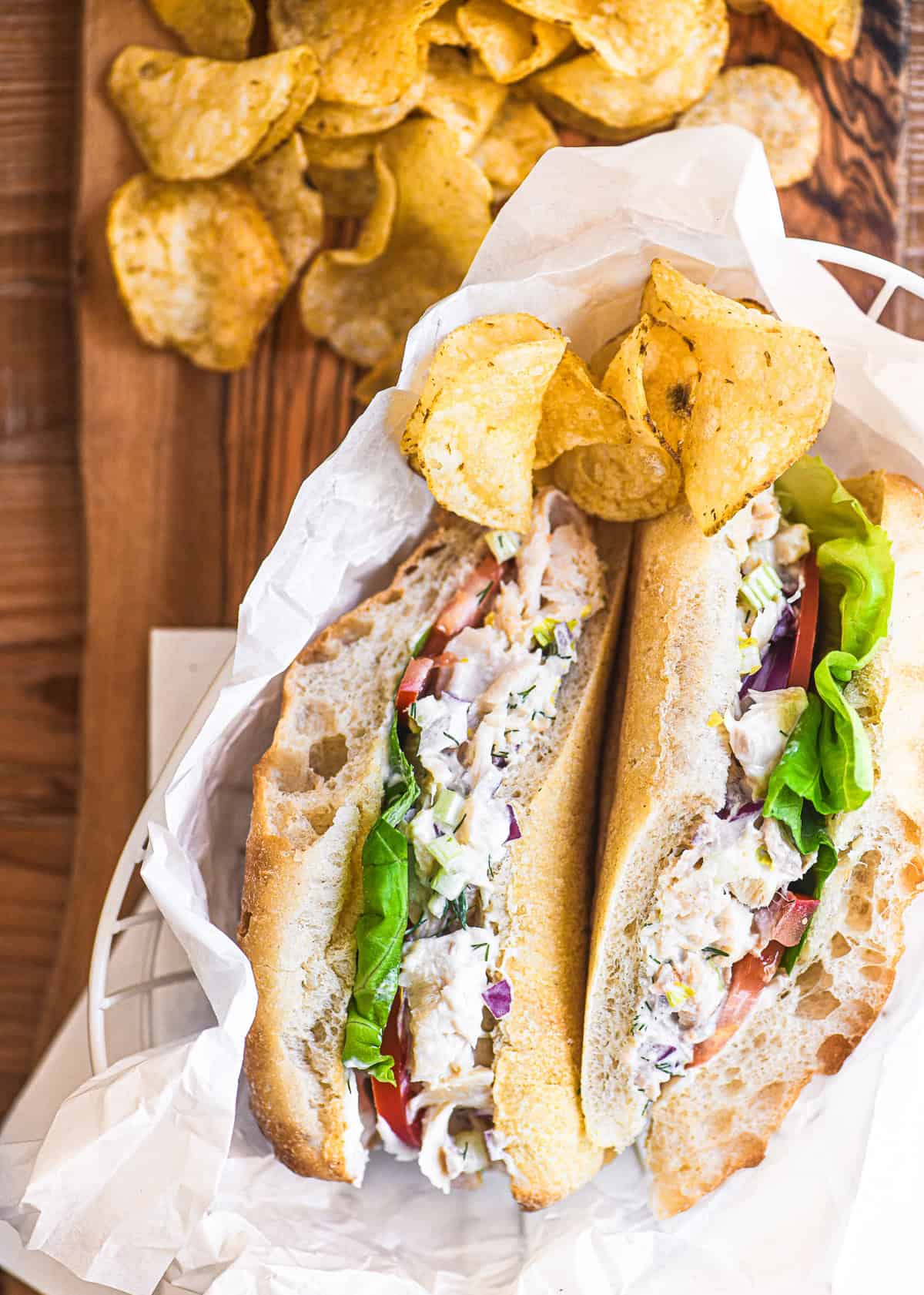 Smoked trout salad sandwich cut and served with chips
