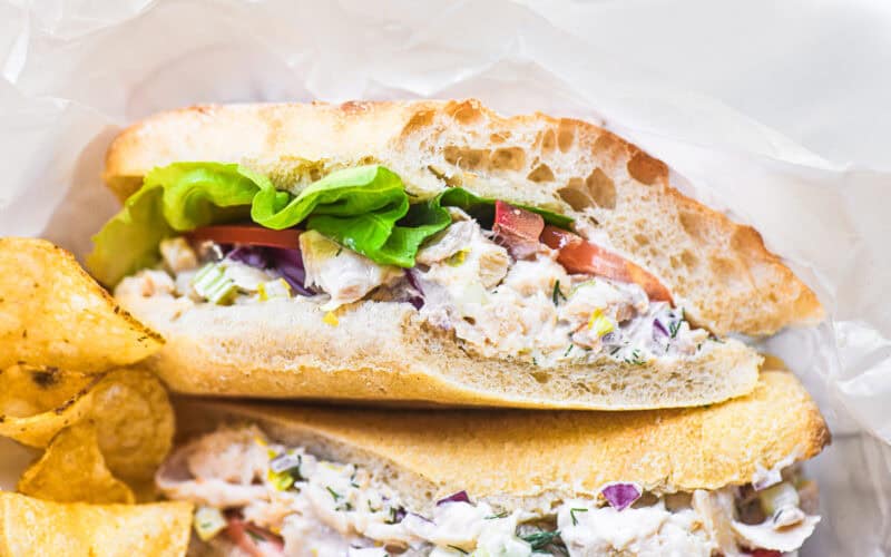 Smoked trout salad sandwich with chips.