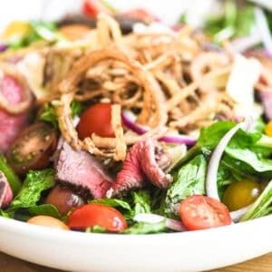 Steak salad topped with crispy fried onions.