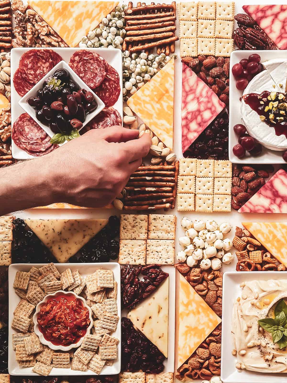 Reaching for some nuts on a star quilt inspired Americana Charcuterie Board.