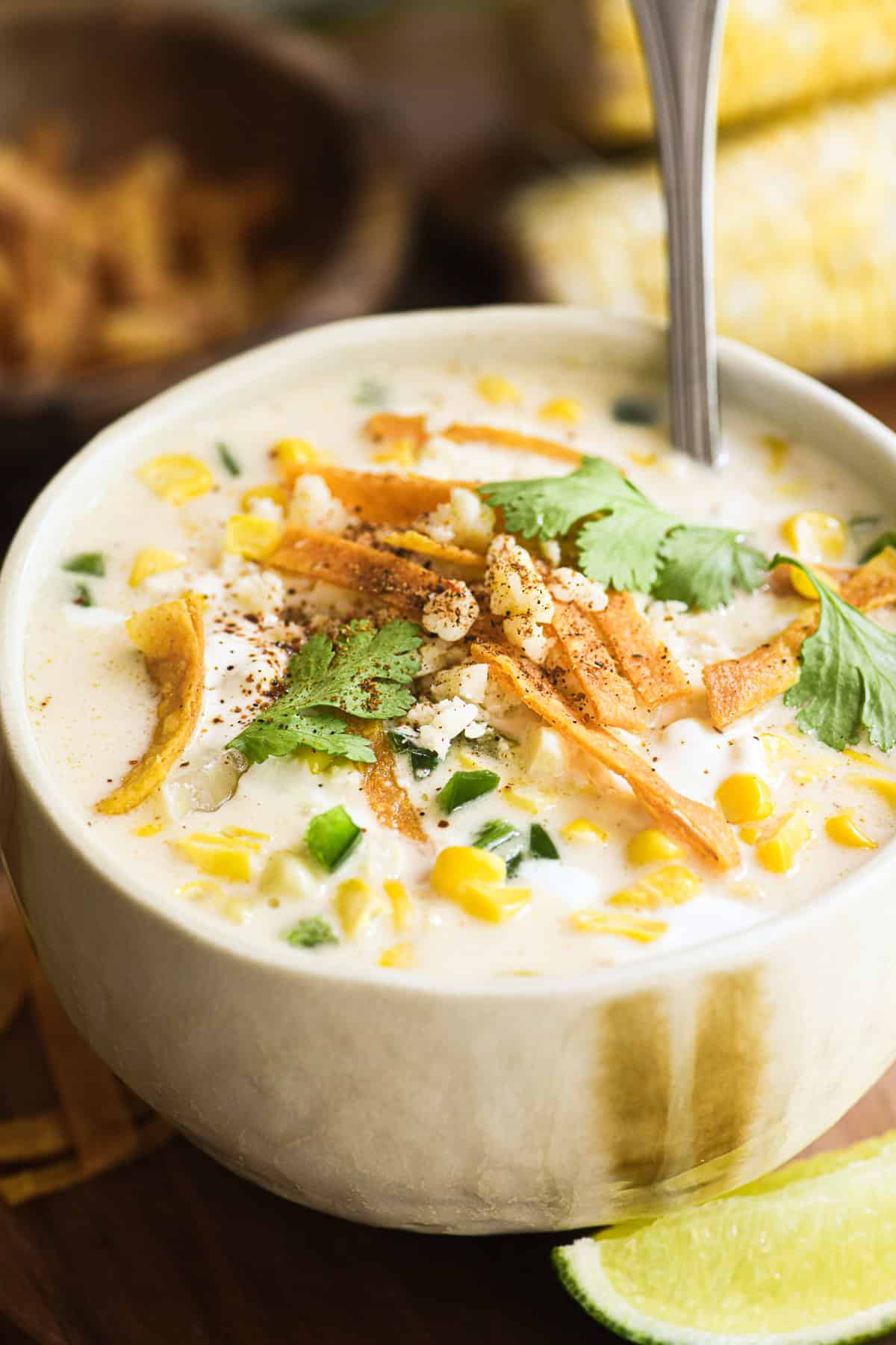 Mexican street corn chowder in a bowl topped with cilantro, crispy tortilla strips, and chile.