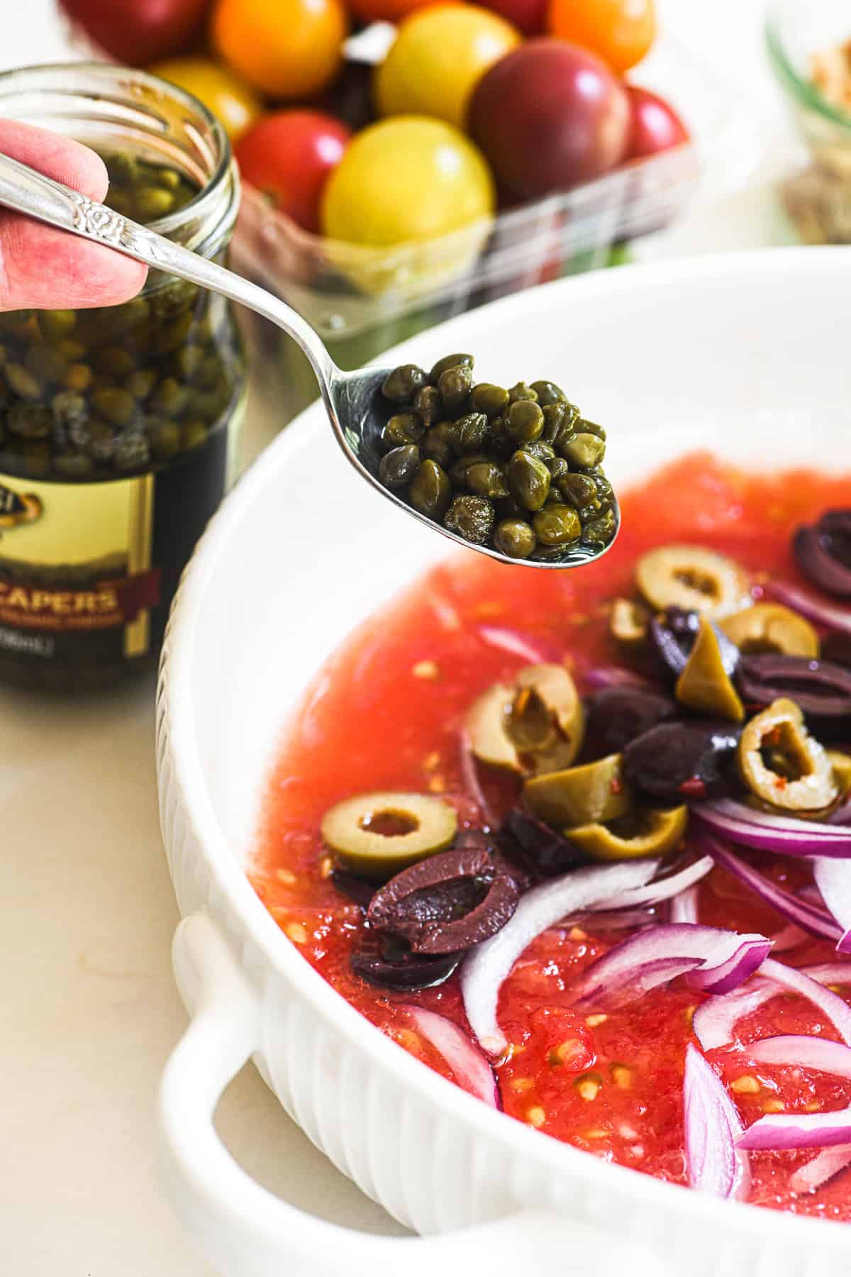 Adding capers to no cook Mediterranean pasta sauce.