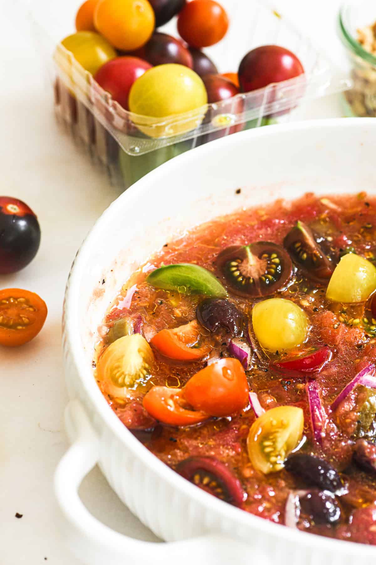 Raw pasta sauce in a white bowl, ready to toss with thin spaghetti.
