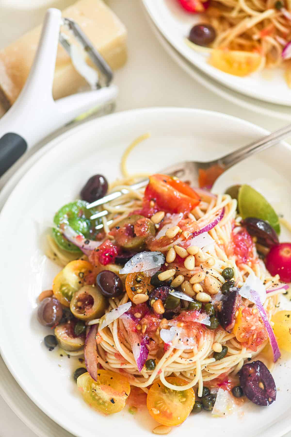 Spaghetti with no-cook Mediterranean pasta sauce, topped with toasted pine nuts and Parm shavings.