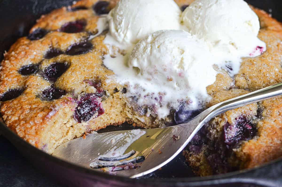Cherry almond skillet cake with a scoop taken out.