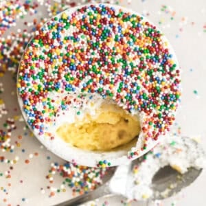 Viral lemon dot cake, topped with nonpareil sprinkles, with bite taken.