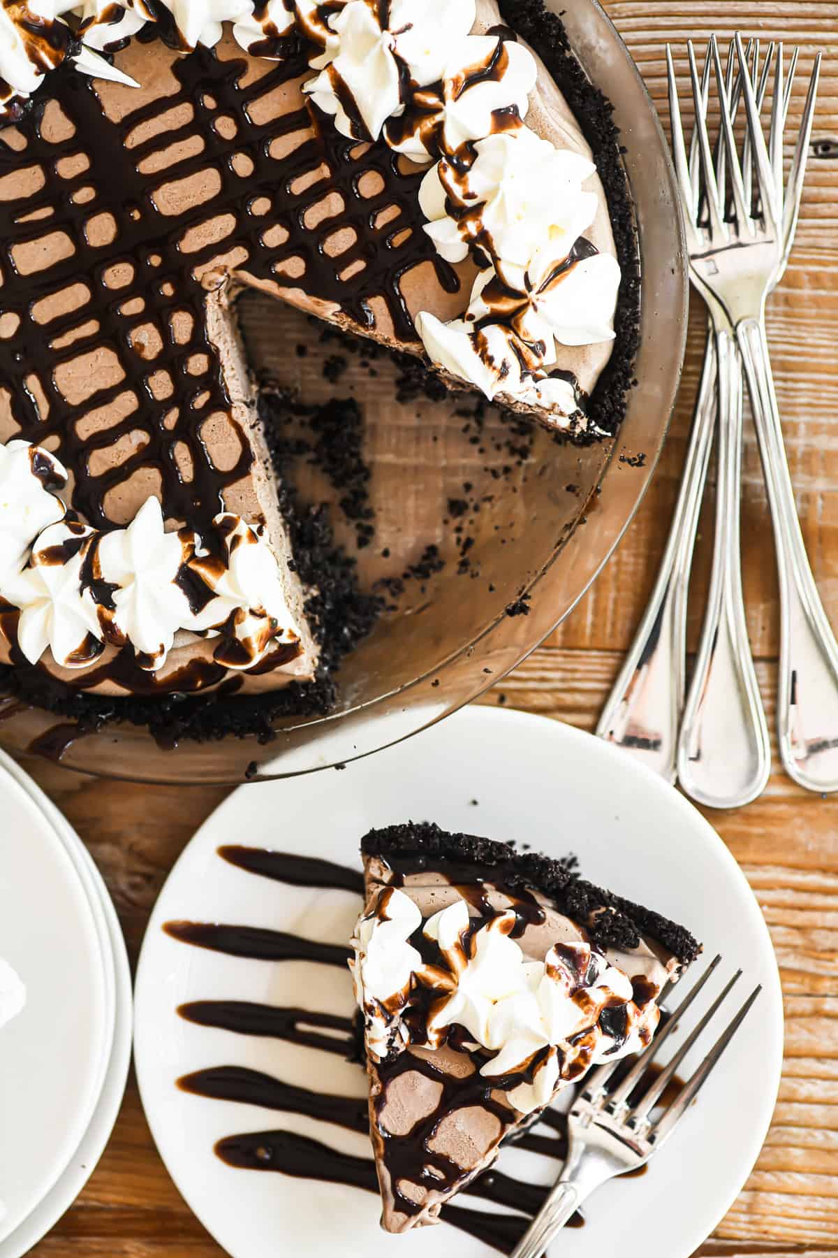 Frozen mudslide pie, with slice on a plate, with chocolate drizzle.