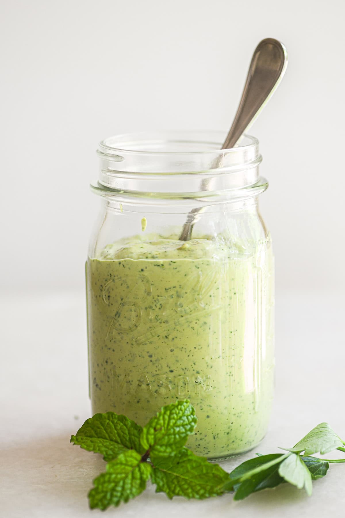 Green tahini sauce in a jar.