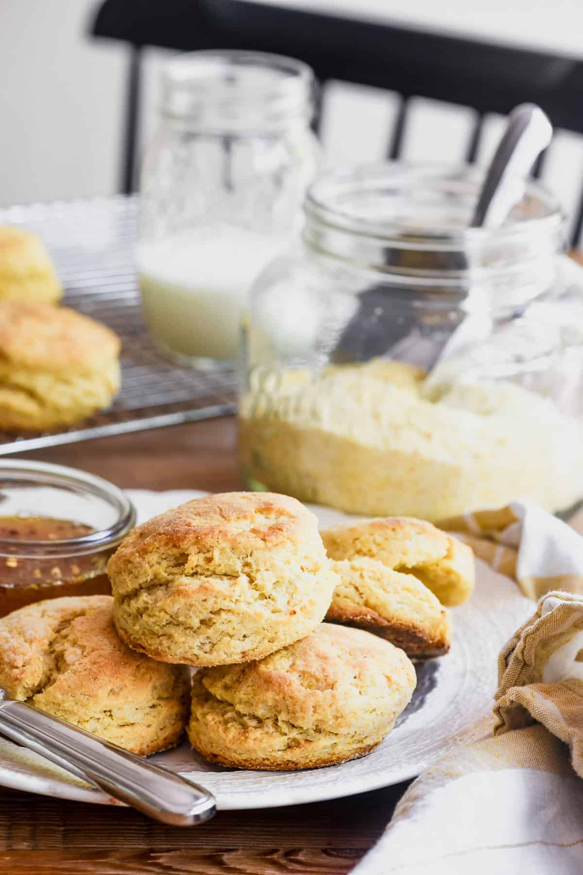 Hot honey corn biscuits on a plate with a small dish of hot honey.