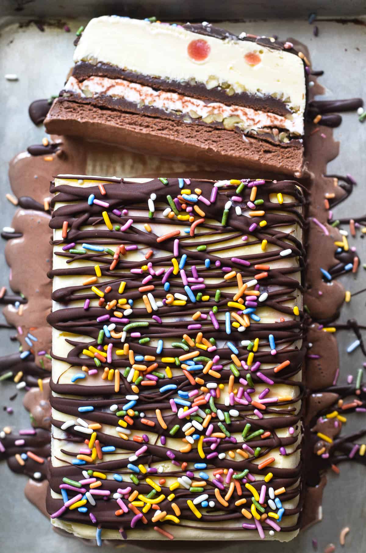 an ice cream sundae terrine topped with magic shell sauce and sprinkles.