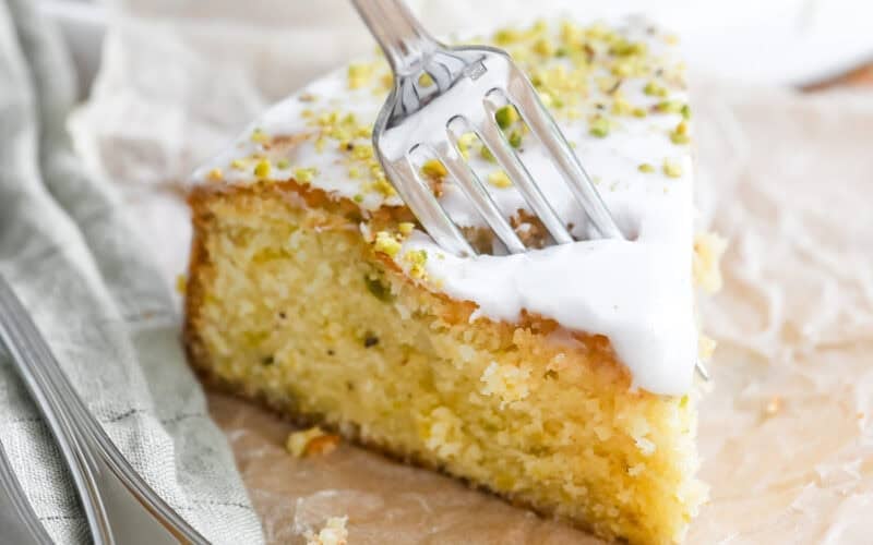 Taking a bite of a slice of lemon pistachio cake.