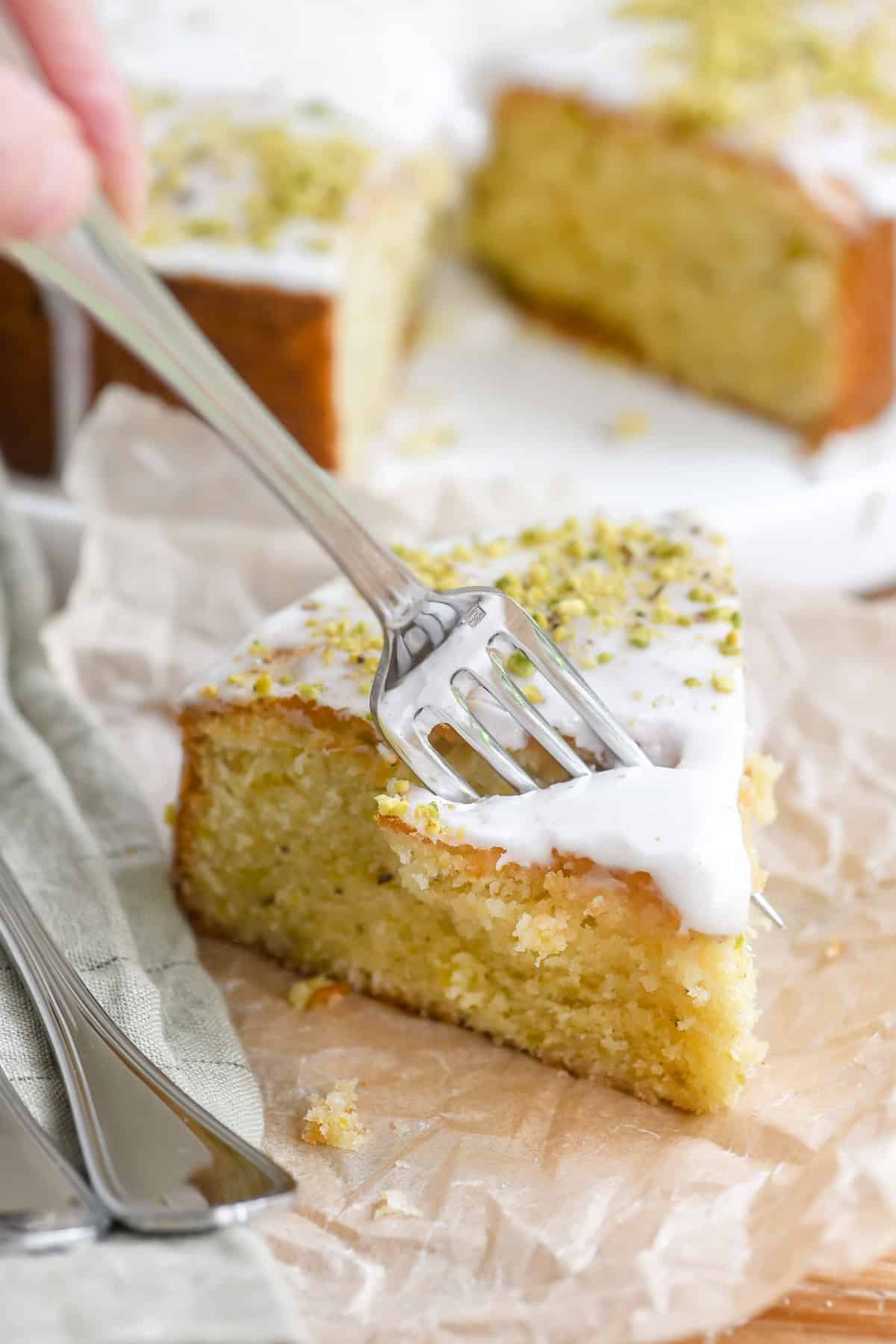 Taking a bite of a piece of lemon pistachio cake.