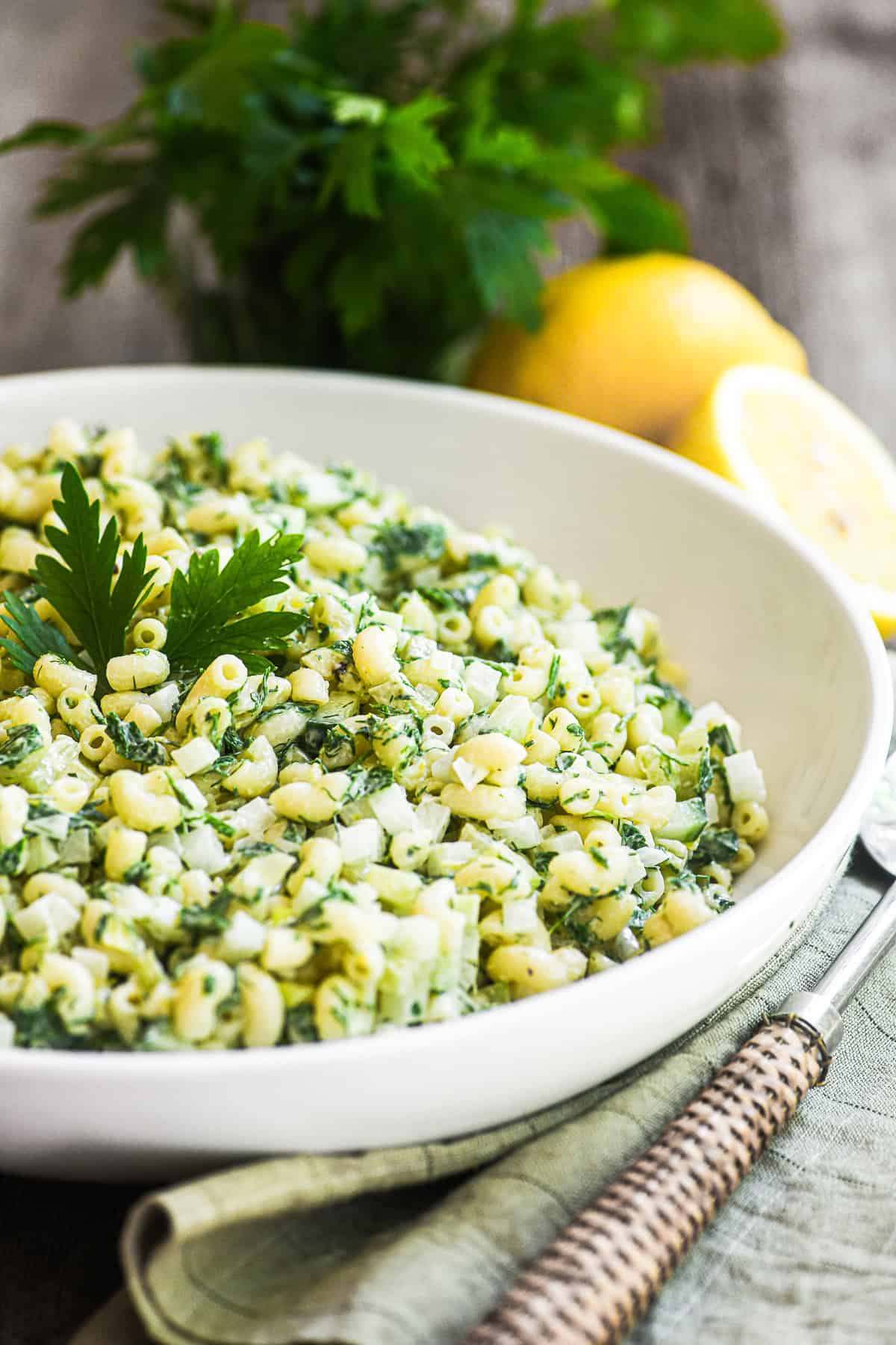 lemon herb macaroni salad in a bowl with fresh parsley.