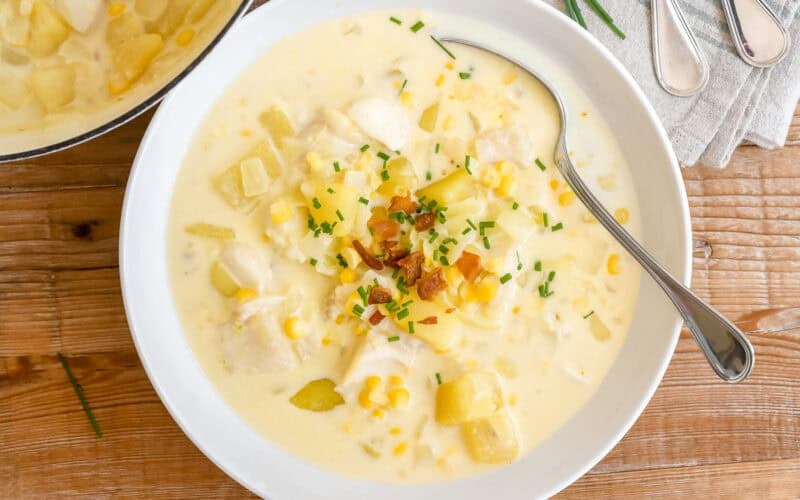 A vowl of classic New England Fish Chowder topped with bacon and oyster crackers.